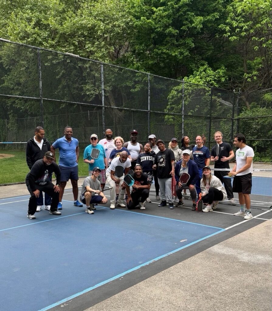 Players mid-rally on the court at Harlem